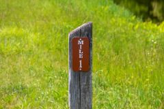 Mile marker in front of green grass close up
