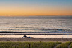Family sitting on the beach at sunset (Old Orchard Beach, ME)