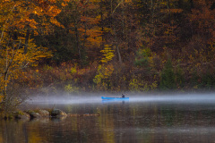 Lone boater on misty waters